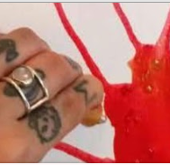 Tattooed hand with red paint